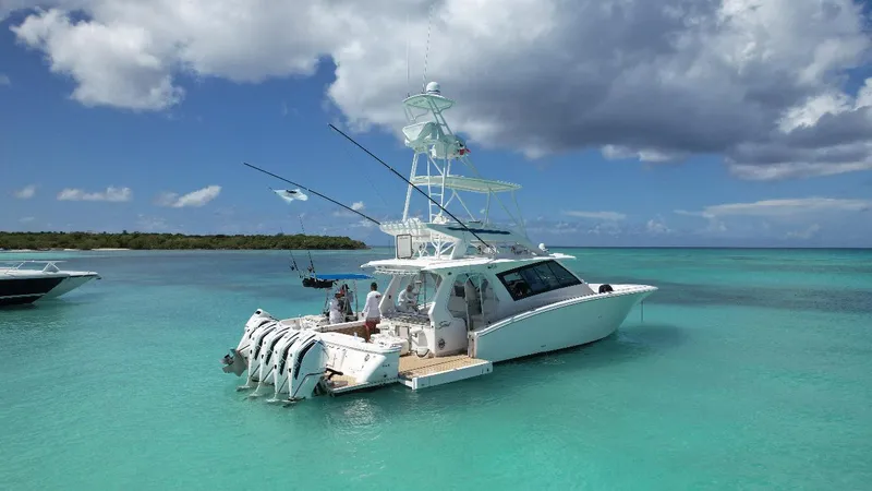 Slide: The Image of 2021 Scout 530 LXF boat in turquoise waters under a partly cloudy sky. - 16