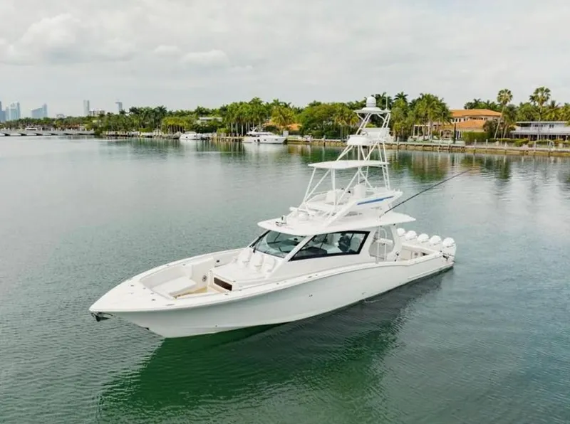 Slide: The Image of 2021 Scout 530 LXF luxury yacht on calm water near a tropical shoreline. - 3