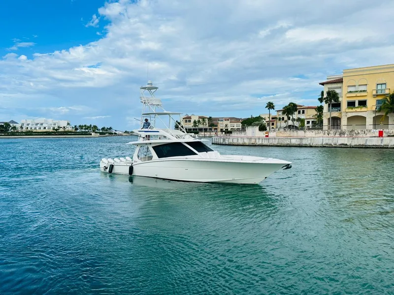 Slide: The Image of 2021 Scout 530 LXF boat cruising in a scenic waterfront area. - 7