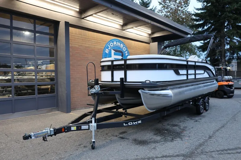 Slide: The Image of 2026 Lowe SS 230 CL pontoon boat on trailer outside dealership. - 13