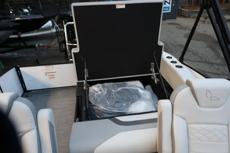 Slide: The Image of 2026 Lowe SS 230 CL boat interior with open storage compartment and white seating. - 34