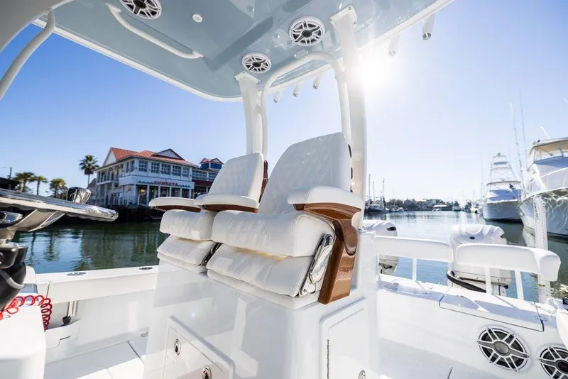 Slide: The Image of 2024 Freeman 28 boat interior with luxurious seating, docked near waterfront homes. - 8