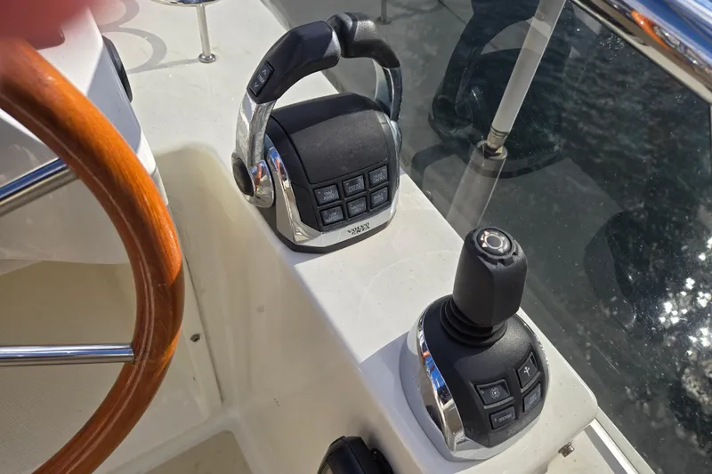 Slide: The Image of Control panel on 2017 Sabre 48 Fly Bridge yacht, featuring joystick and cup holders. - 16