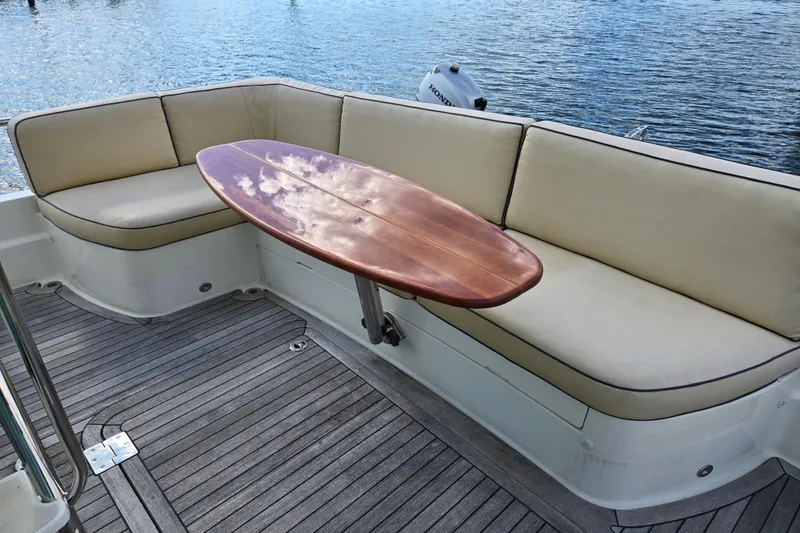 Slide: The Image of Flybridge seating area on 2017 Sabre 48 Fly Bridge with wooden table. - 21