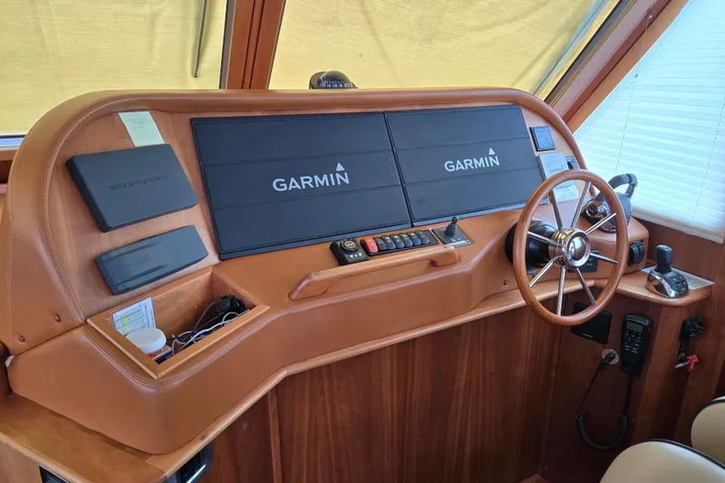 Slide: The Image of Polished wooden table inside 2017 Sabre 48 Fly Bridge yacht, with blue seating and magazines. - 35