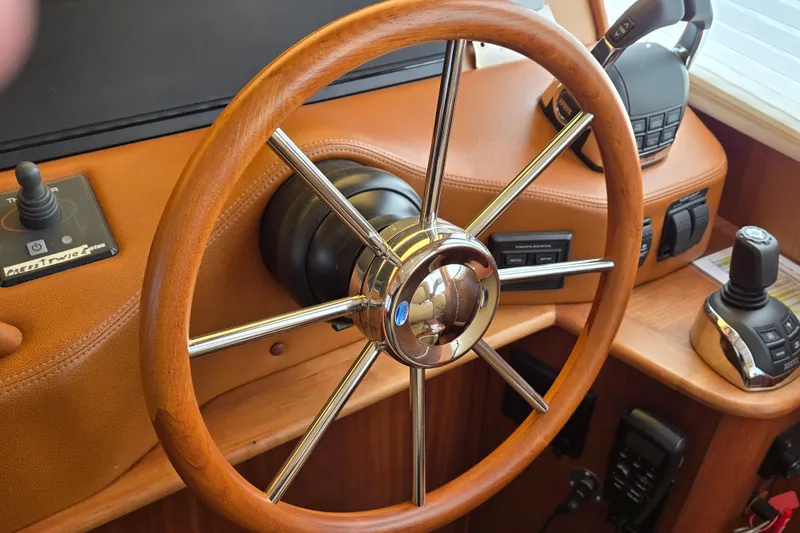 Slide: The Image of Interior view of 2017 Sabre 48 Fly Bridge yacht with steering wheel and water outside. - 38