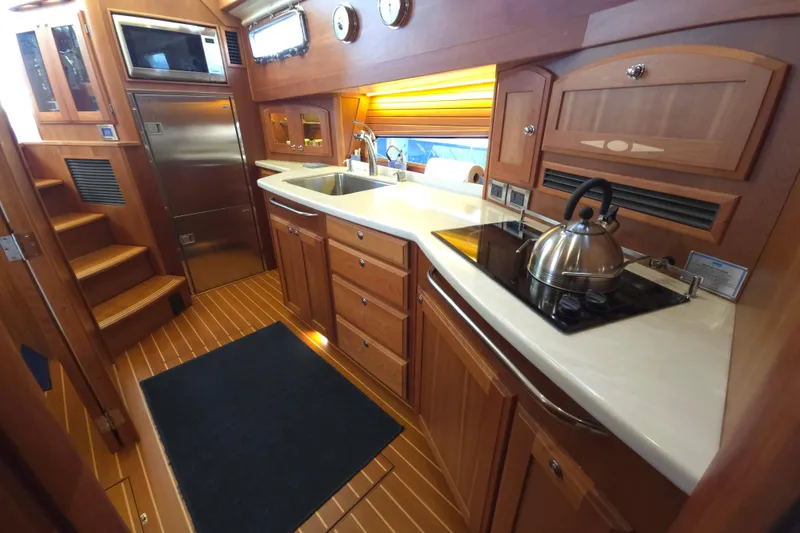 Slide: The Image of Interior of 2017 Sabre 48 Fly Bridge yacht with wooden cabinetry and control panels. - 49