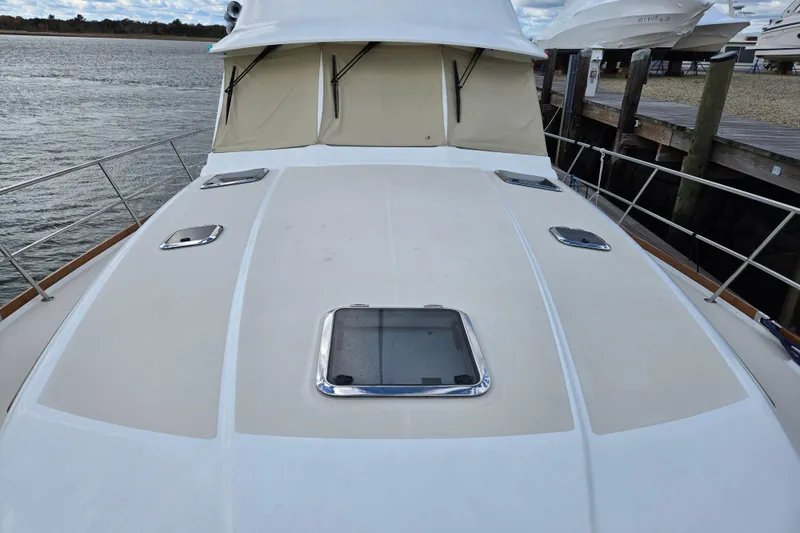 Slide: The Image of 2017 Sabre 48 Fly Bridge helm with Garmin navigation, wooden steering wheel, and marina view. - 5
