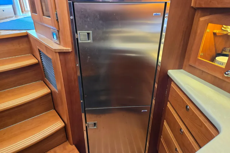 Slide: The Image of Luxurious 2017 Sabre 48 Fly Bridge yacht kitchen with wooden cabinetry and modern appliances. - 50