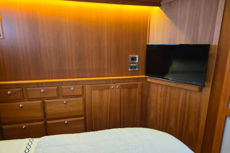 Slide: The Image of Luxurious 2017 Sabre 48 Fly Bridge cabin with wooden interior and cozy bedding. - 61