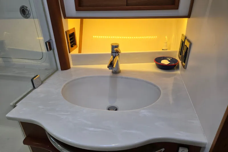 Slide: The Image of Luxurious wood-paneled cabin interior of 2017 Sabre 48 Fly Bridge yacht with TV and drawers. - 63