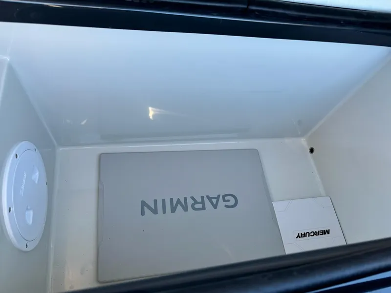 Slide: The Image of Open storage compartment with Garmin and Mercury equipment, Skipper-BSK 34, 2025 model. - 22