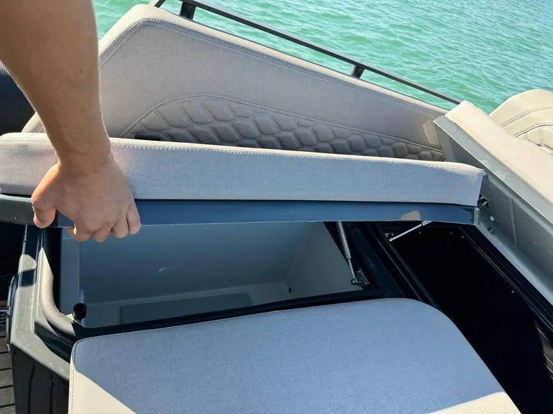 Slide: The Image of Person opening storage compartment on Skipper-BSK 34 boat, 2025 model, near water. - 23