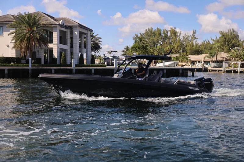 Slide: The Image of Skipper-BSK 34 boat cruising near waterfront homes, 2025 model. - 3