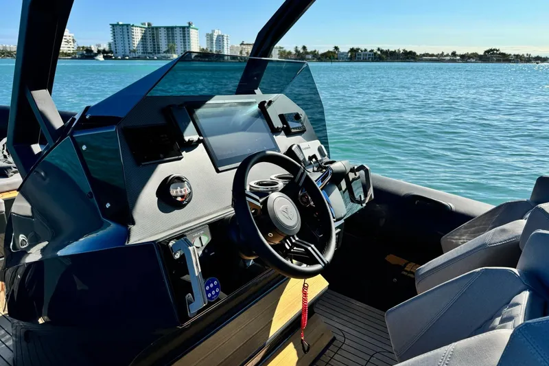 Slide: The Image of Interior of 2025 Skipper-BSK 34 boat, featuring modern dashboard and steering wheel on calm water. - 34
