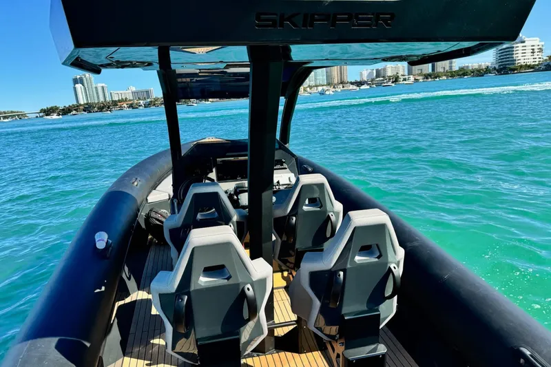 Slide: The Image of Skipper-BSK 34 boat interior, 2025 model, on clear blue water with city skyline. - 35