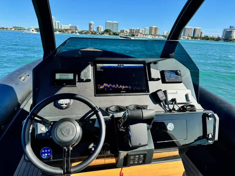 Slide: The Image of Cockpit of 2025 Skipper-BSK 34 boat with modern navigation equipment, city skyline in background. - 14