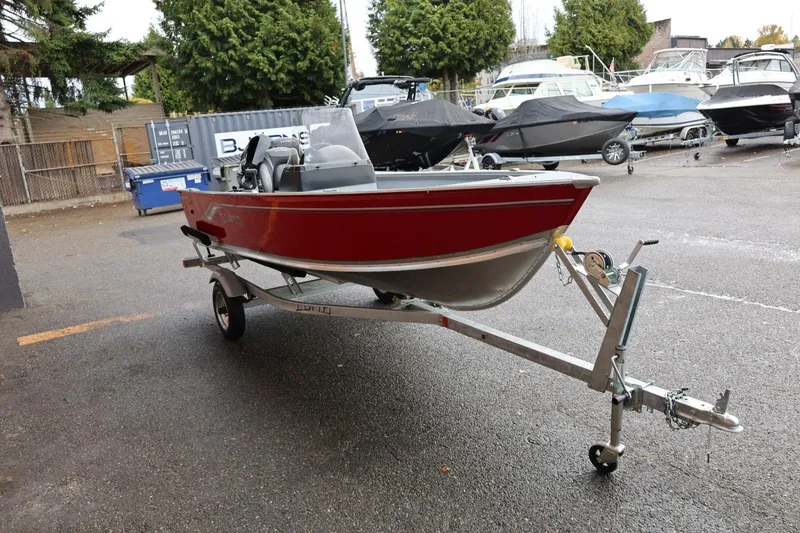 Slide: The Image of 2026 Lund 1400 Fury SS boat on trailer in a marina parking lot. - 10