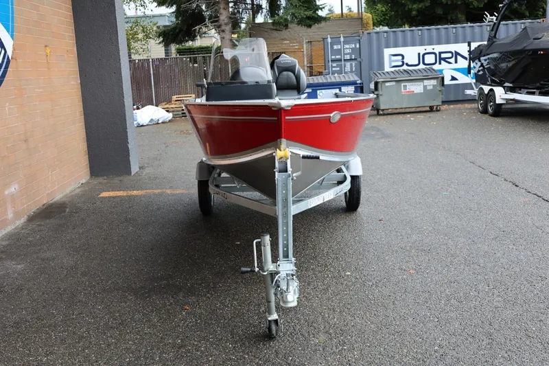 Slide: The Image of 2026 Lund 1400 Fury SS boat in red, parked on a trailer outdoors. - 12