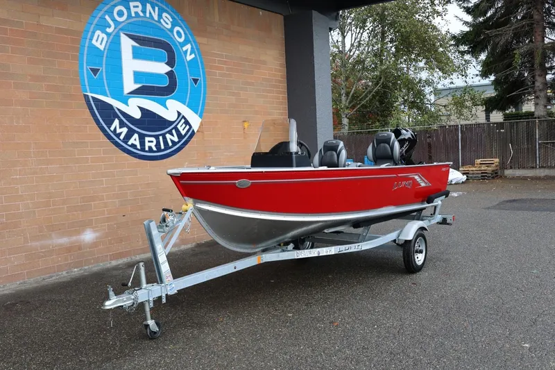 Slide: The Image of 2026 Lund 1400 Fury SS boat in red on trailer at Bjornson Marine. - 14