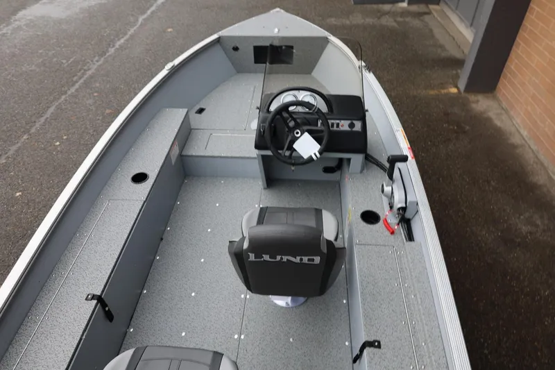 Slide: The Image of 2026 Lund 1400 Fury SS boat interior with steering console and seating. - 16