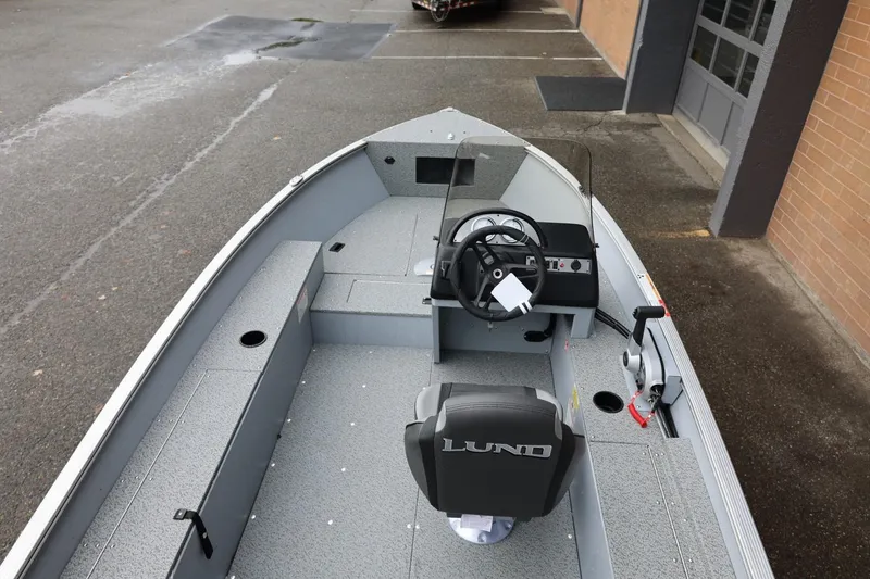 Slide: The Image of 2026 Lund 1400 Fury SS boat interior with steering console and seating. - 17