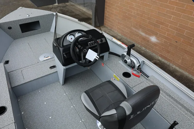 Slide: The Image of 2026 Lund 1400 Fury SS boat interior with steering wheel and control panel. - 19