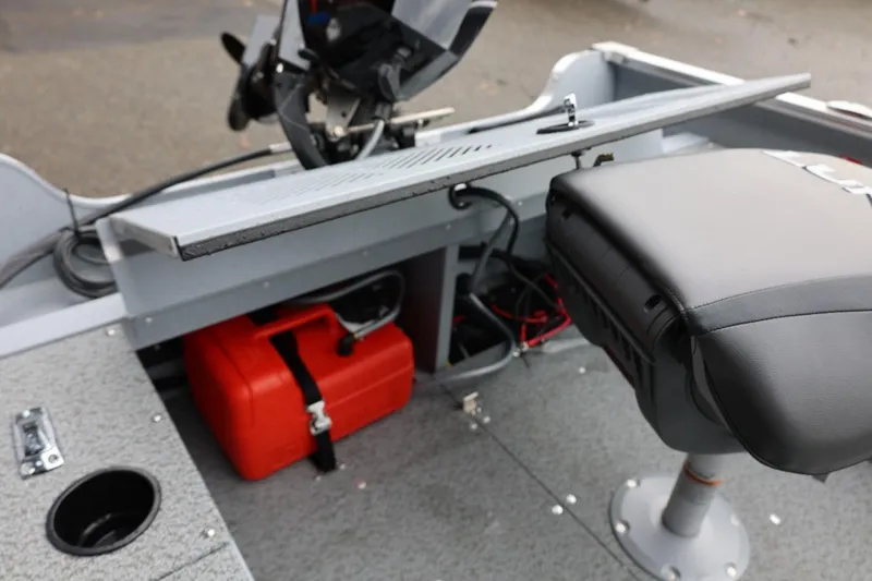 Slide: The Image of 2026 Lund 1400 Fury SS boat interior with seat, motor, and red fuel tank. - 25
