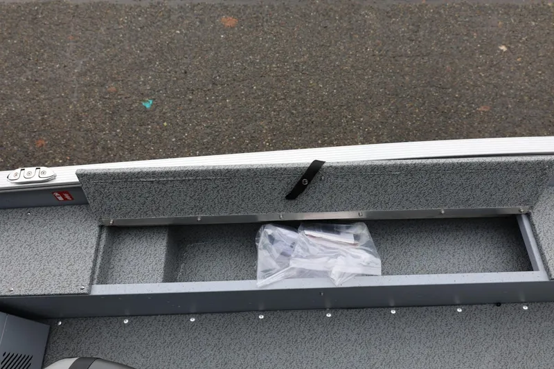 Slide: The Image of 2026 Lund 1400 Fury SS boat interior storage compartment with gray textured finish. - 26