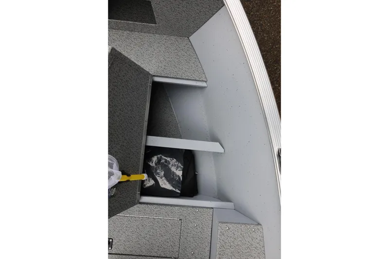 Slide: The Image of 2026 Lund 1400 Fury SS boat interior with storage compartment and fishing net. - 29