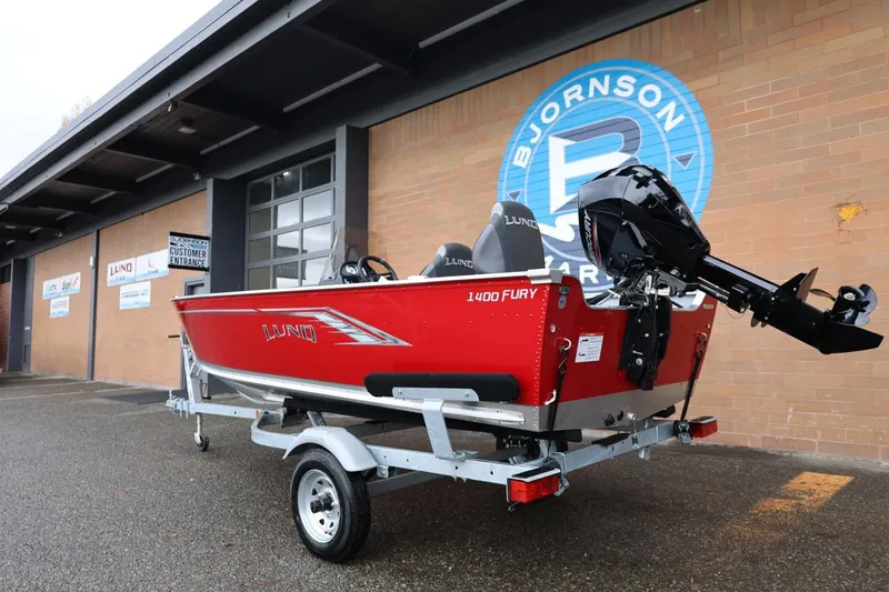 Slide: The Image of 2026 Lund 1400 Fury SS boat on trailer outside Bjornson Marine building. - 4
