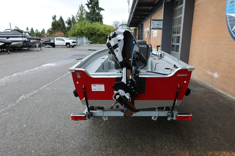 Slide: The Image of 2026 Lund 1400 Fury SS boat with motor, parked outdoors near a building. - 5