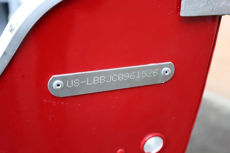 Slide: The Image of 2026 Lund 1400 Fury SS boat identification plate on red surface. - 7