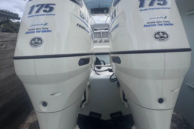 Slide: The Image of 2015 Dusky 278 boat interior with seating and console, parked in a residential area. - 14