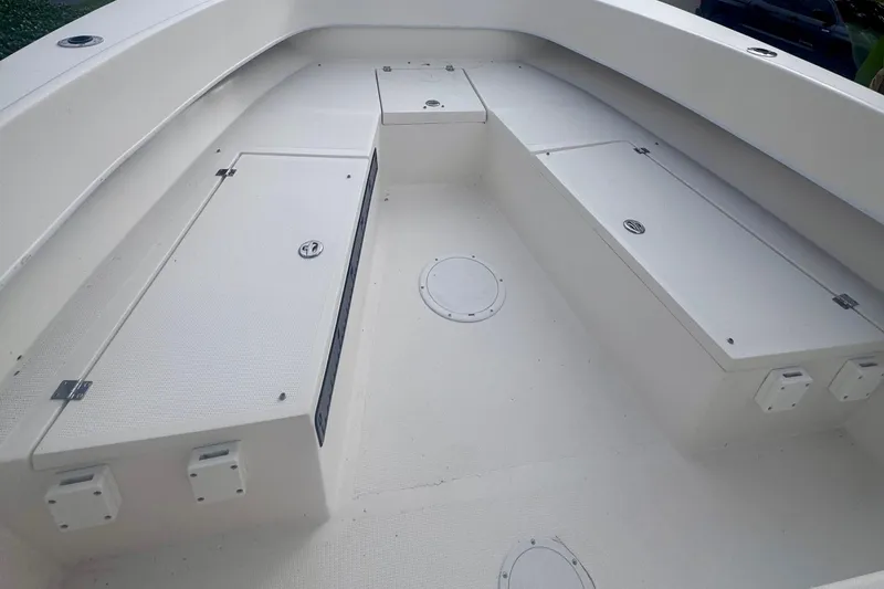 Slide: The Image of Interior of a 2015 Dusky 278 boat, featuring storage compartments and seating area. - 17