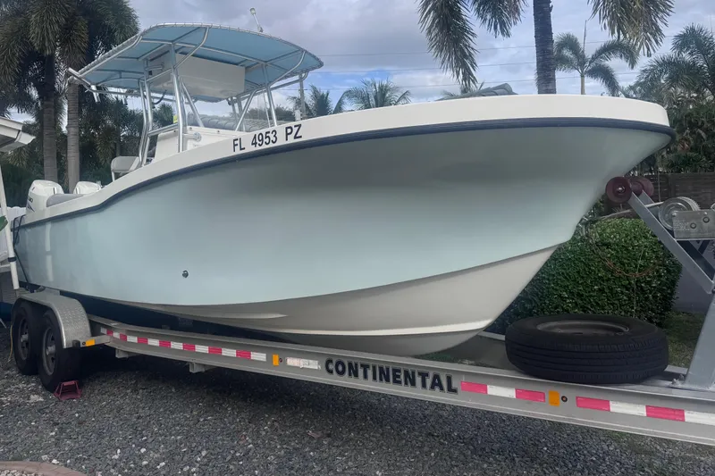 Slide: The Image of Dusky 278 boat on trailer, 2015 model, parked with palm trees in background. - 2