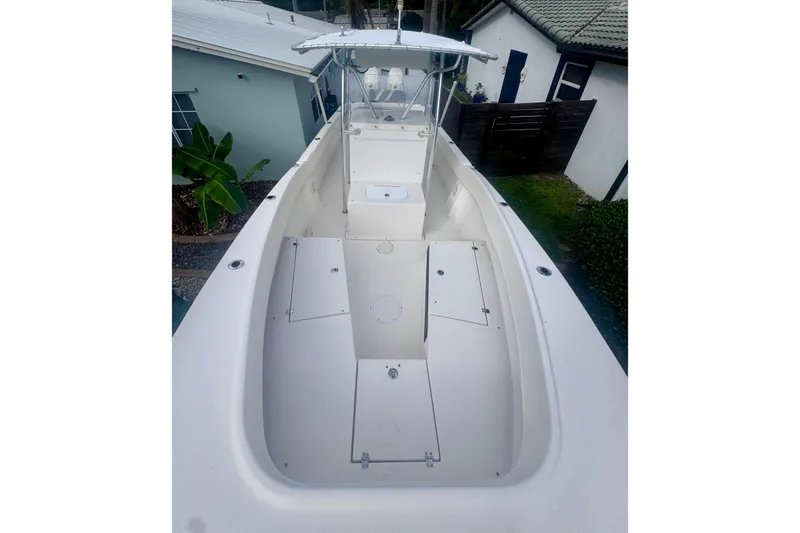 Slide: The Image of 2015 Dusky 278 boat with white deck and blue canopy, parked near tropical plants. - 20