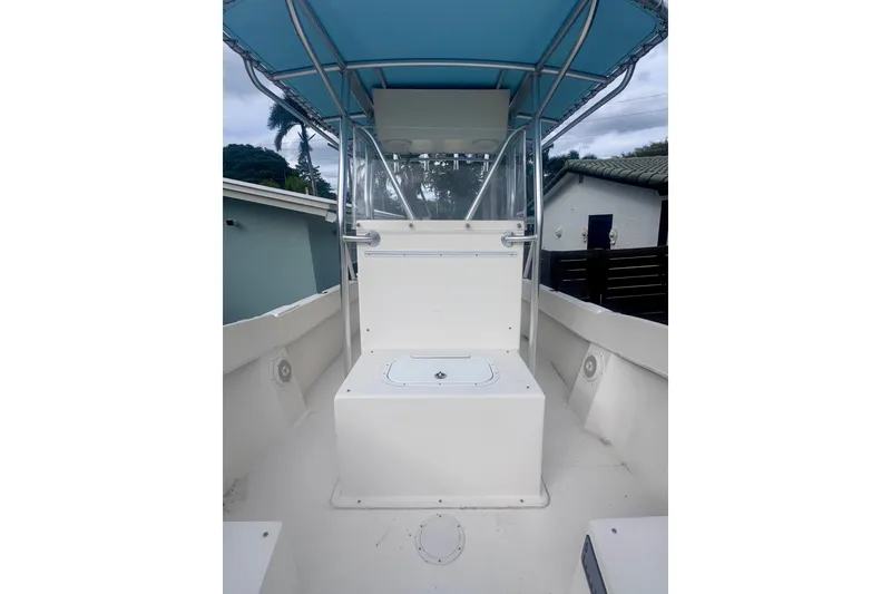 Slide: The Image of 2015 Dusky 278 boat deck with seating and railing, surrounded by tropical trees. - 23