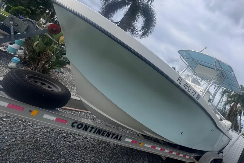 Slide: The Image of 2015 Dusky 278 boat with Suzuki outboard motor, parked on gravel. - 7