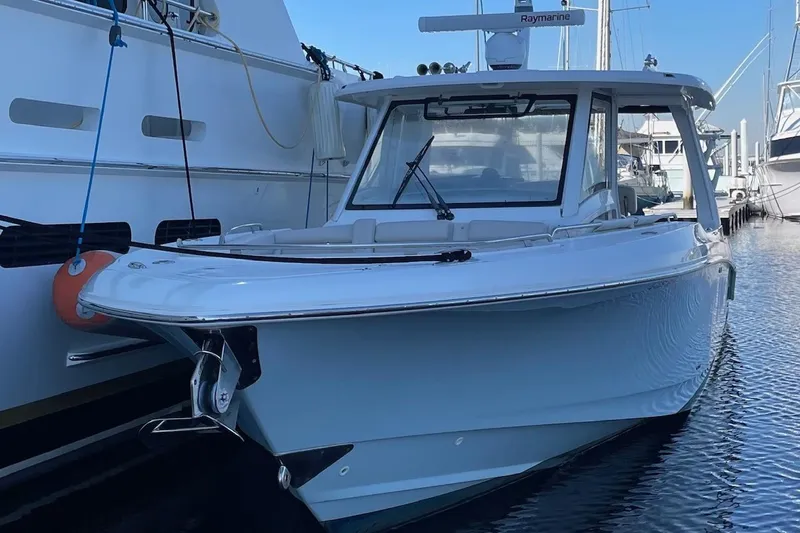 Slide: The Image of 2020 Boston Whaler 350 Realm boat docked in marina, showcasing sleek design. - 1