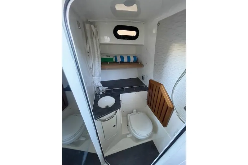 Slide: The Image of 2020 Boston Whaler 350 Realm boat bathroom with sink, toilet, and storage shelf. - 12