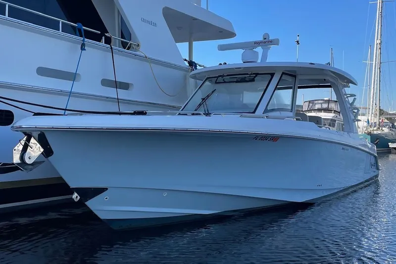 Slide: The Image of 2020 Boston Whaler 350 Realm boat docked in marina, side view. - 2