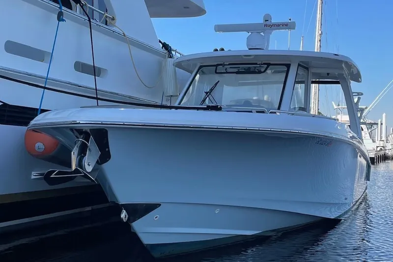 Slide: The Image of 2020 Boston Whaler 350 Realm boat docked in marina, showcasing sleek design. - 3
