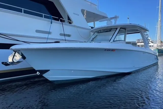 Slide: The Image of 2020 Boston Whaler 350 Realm boat docked in marina, side view. - 4