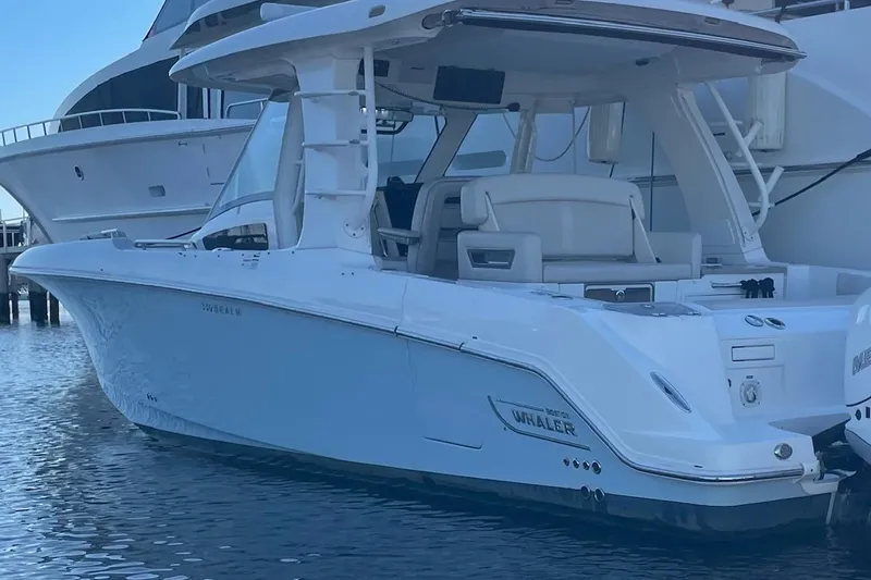 Slide: The Image of 2020 Boston Whaler 350 Realm boat docked in marina, showcasing sleek design and luxury features. - 5