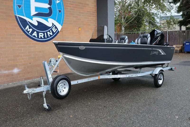 Slide: The Image of 2026 Lund 1600 Fury SS boat on trailer, parked outside marine store. - 13