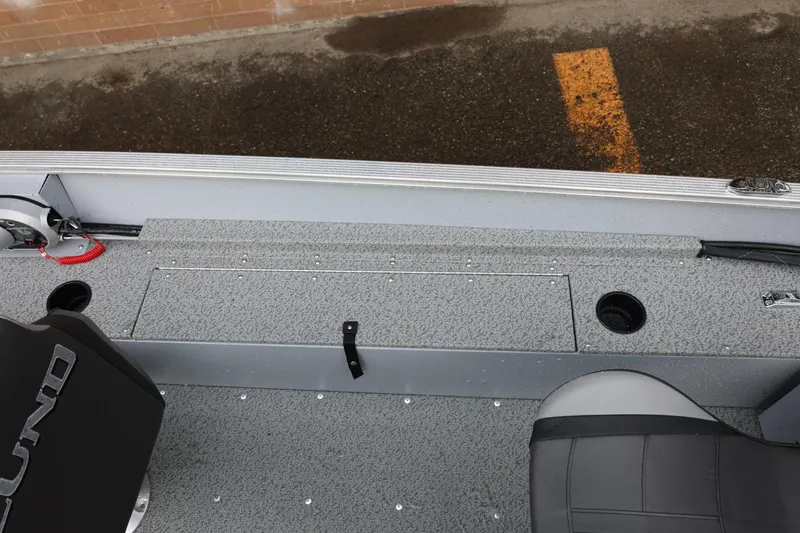 Slide: The Image of 2026 Lund 1600 Fury SS boat interior with gray seating and storage compartment. - 18