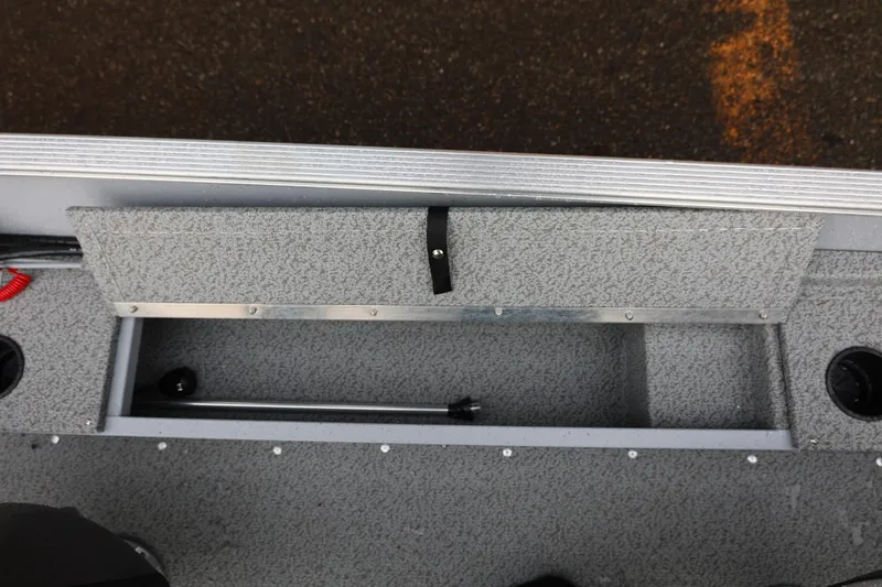 Slide: The Image of Storage compartment in 2026 Lund 1600 Fury SS boat, featuring textured interior and secure latch. - 19