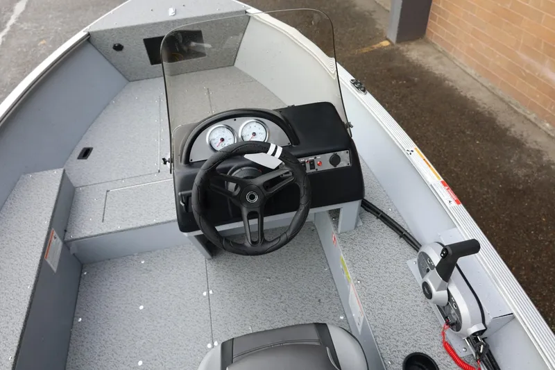 Slide: The Image of 2026 Lund 1600 Fury SS boat interior with steering wheel and control panel. - 24