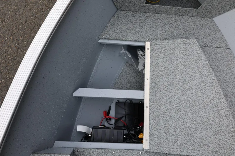 Slide: The Image of 2026 Lund 1600 Fury SS boat interior with storage compartment and battery. - 29